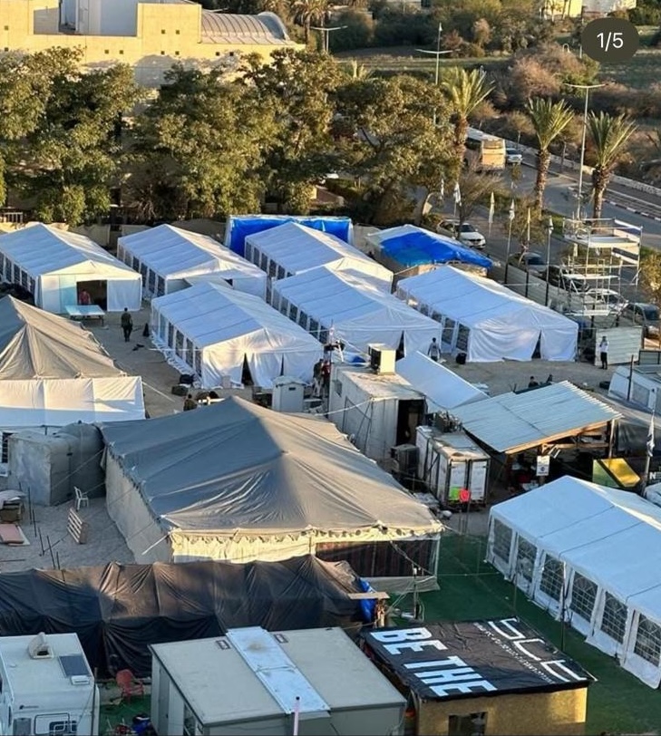 לוחמים יושבים תחת אוהלים כחולים בערב